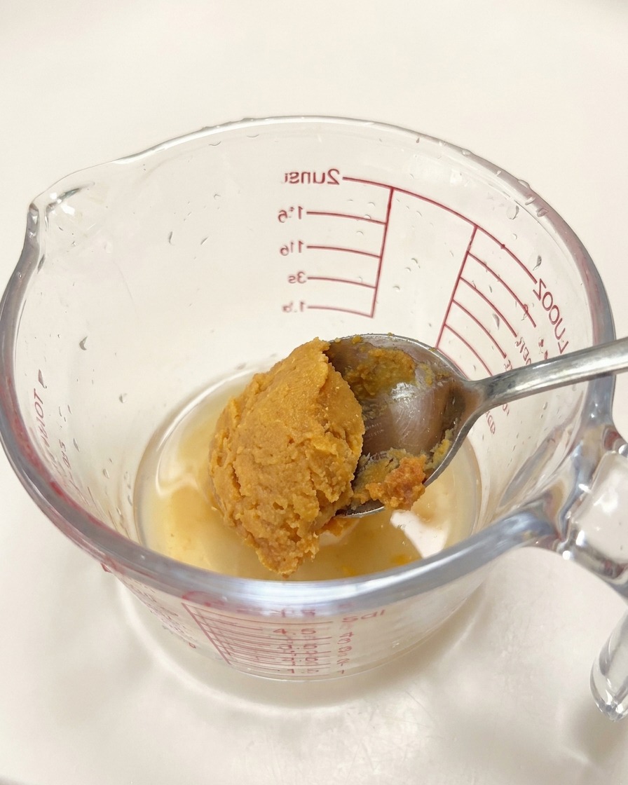 計量カップに味噌、醤油、みりん、ごま油などを加えている様子。