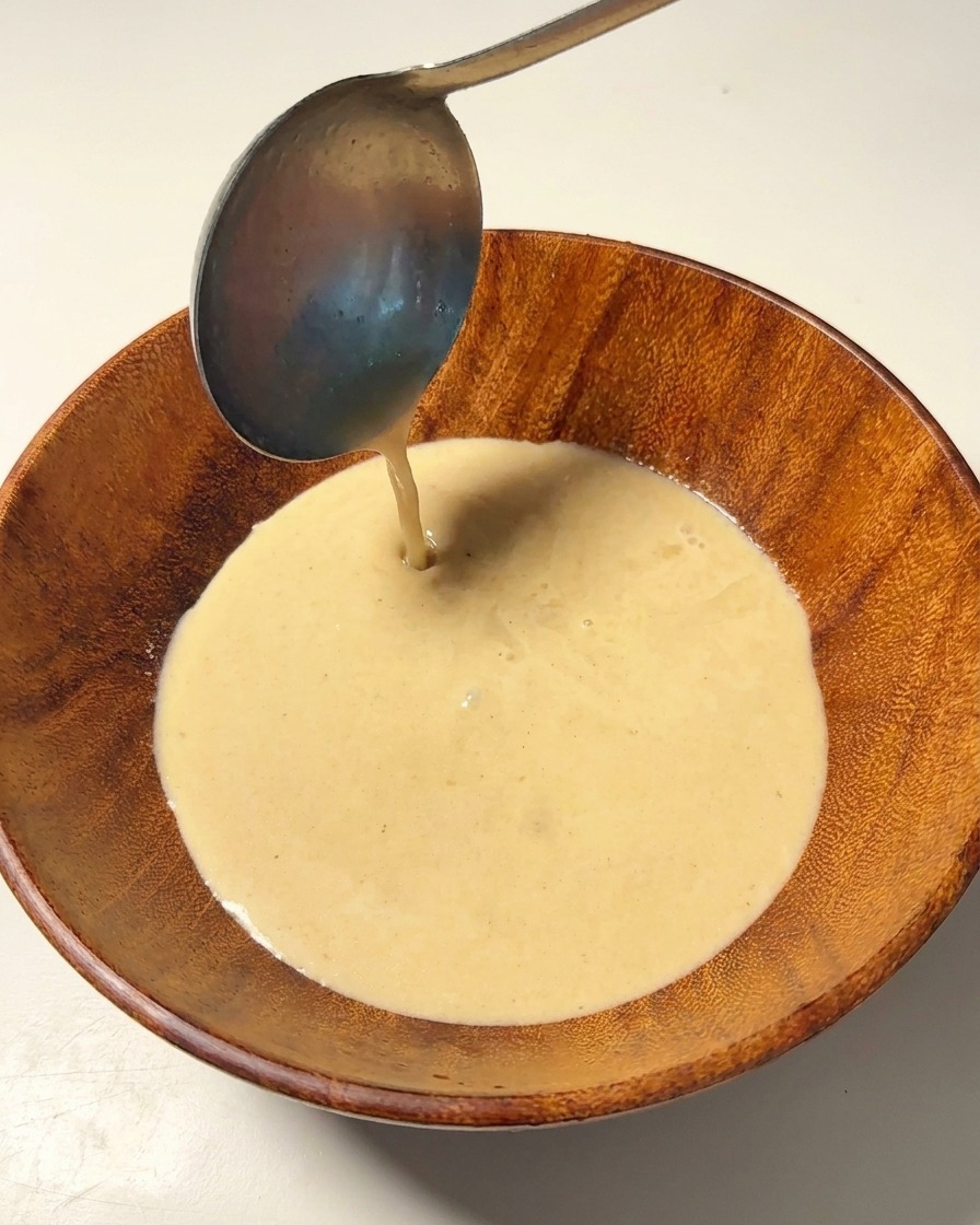 丼のタレに残りの熱い豚骨スープを注ぎ足している様子。