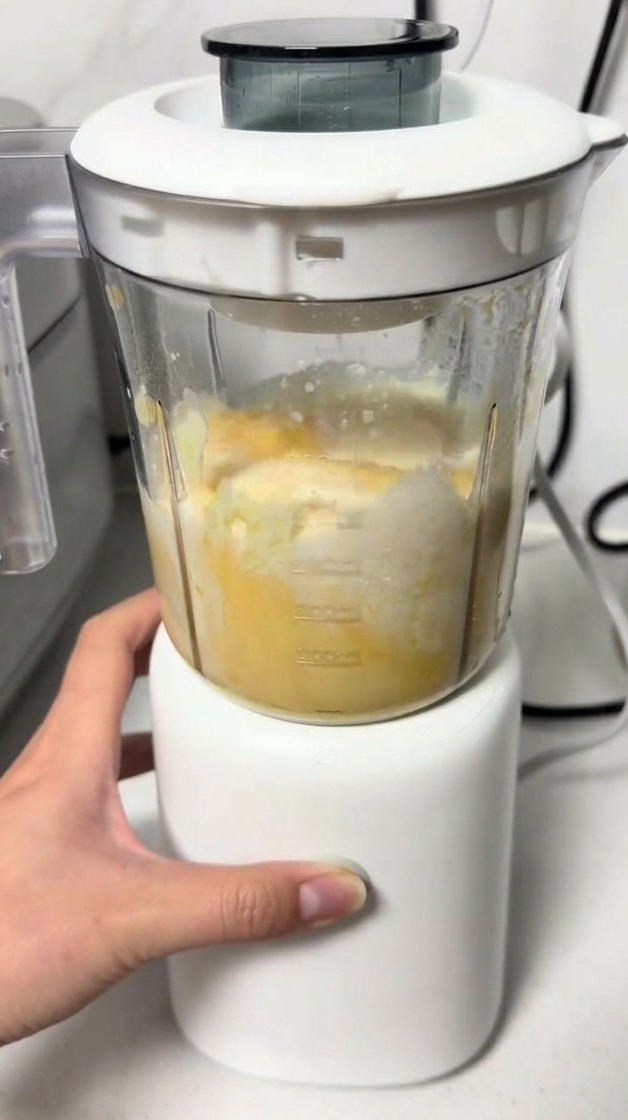 ミキサーで黄色いチーズ生地を滑らかになるまで混ぜ合わせている様子。