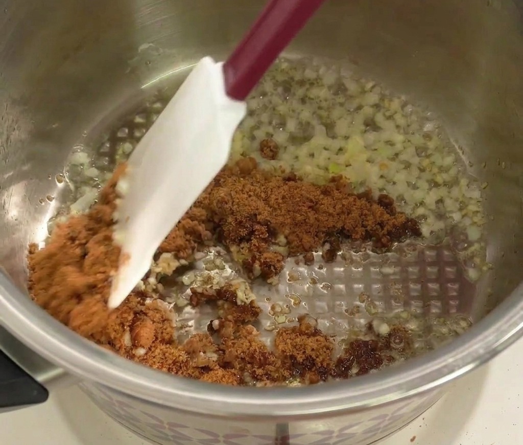 炒めた玉ねぎとにんにくにダークブラウンシュガーを加えて混ぜる様子。