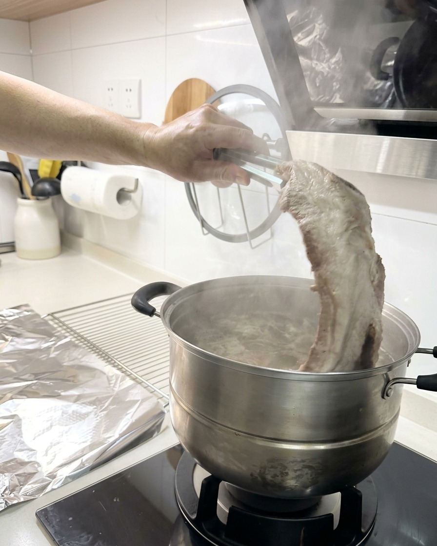 トングを使って、茹で上がったリブを鍋から引き上げている様子。