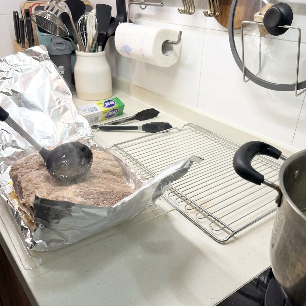 アルミホイルに乗せたリブに、お玉で熱い茹で汁をかけている様子。