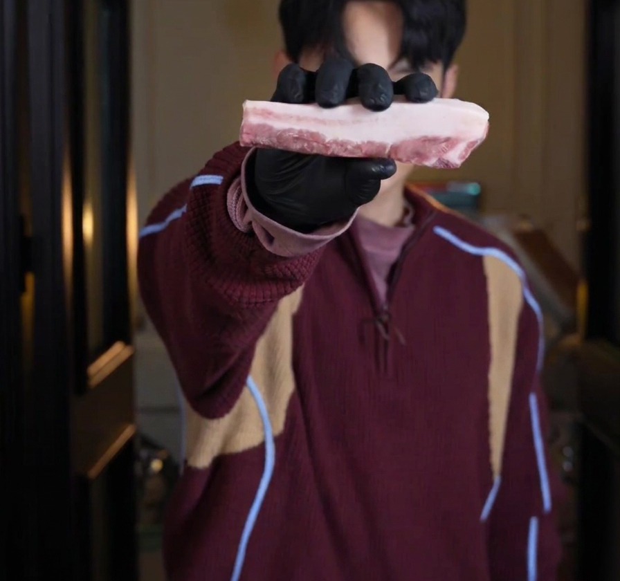 層になった生の厚切り豚バラ肉を手に持っている様子。