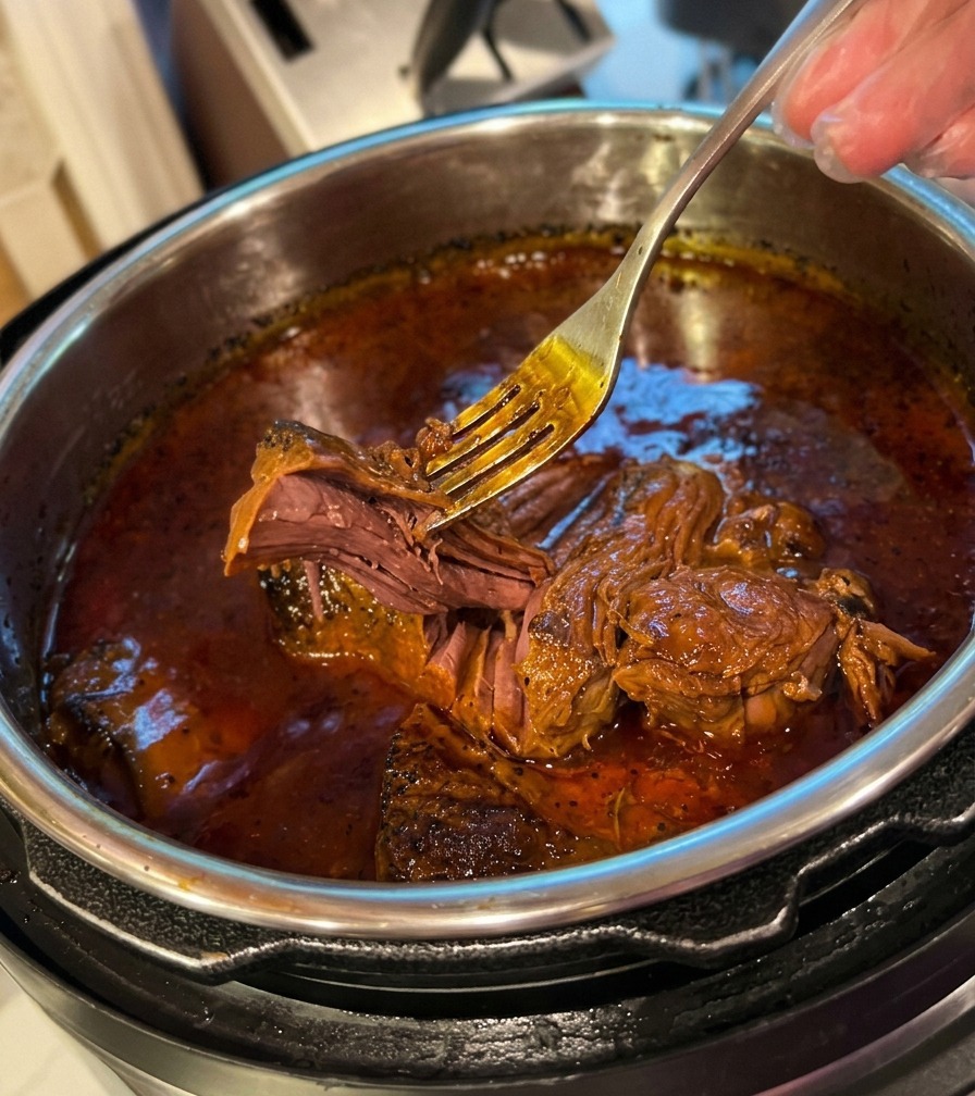 鍋の中で、フォークを使ってホロホロと崩れるほど柔らかくなった肉を確認している様子。