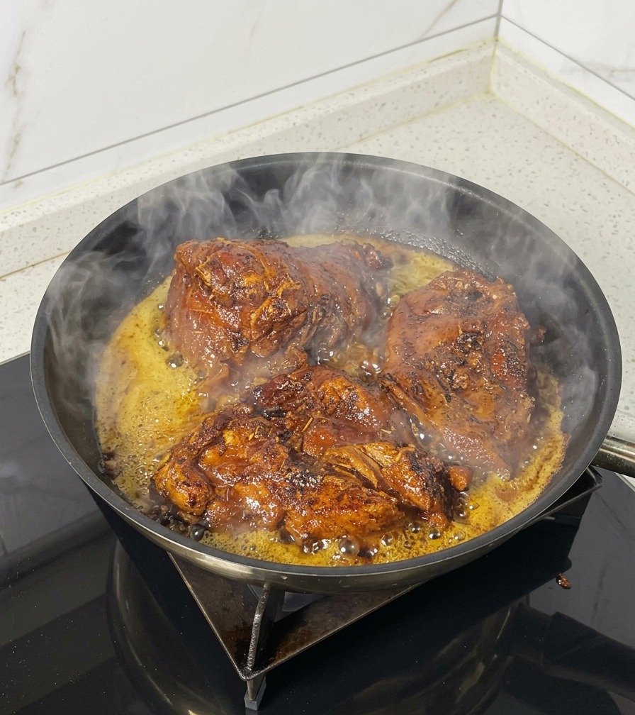 黒いスキレットで、下味をつけた大きな豚肉がジューシーに焼けている様子。