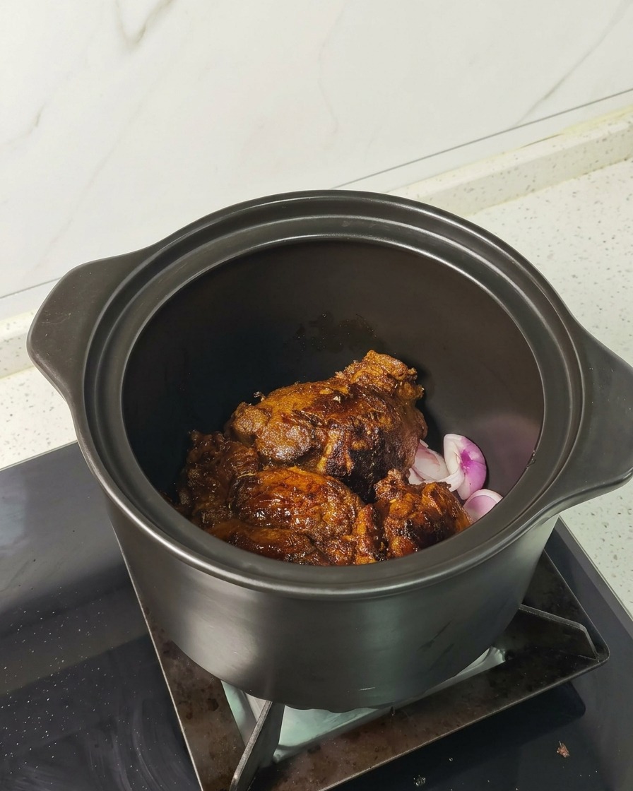 表面をこんがり焼いた豚肉を、エシャロットを敷いた煮込み鍋の中に並べている様子。