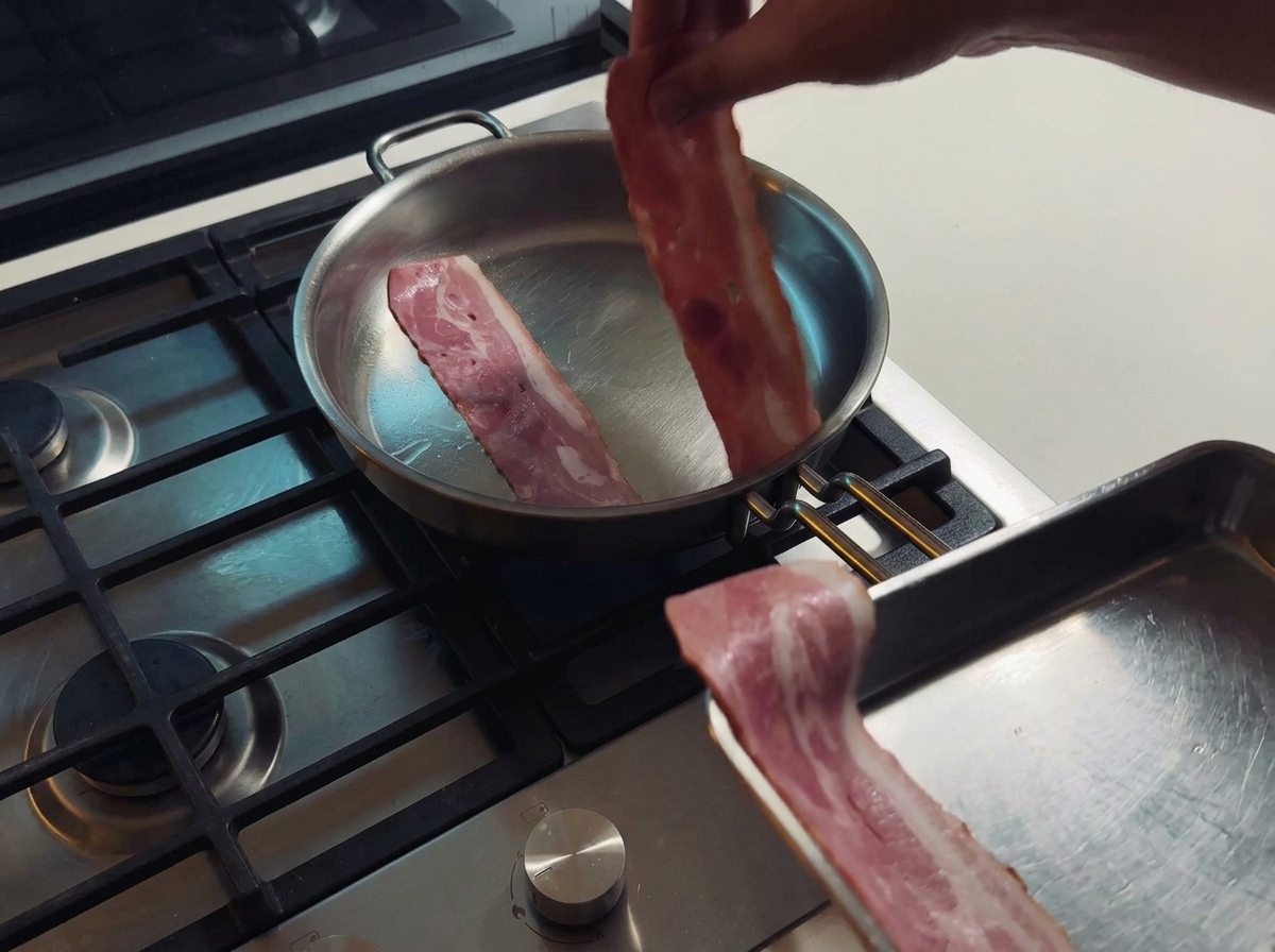 フライパンでベーコンを焼き、旨味の詰まった脂を出している様子。