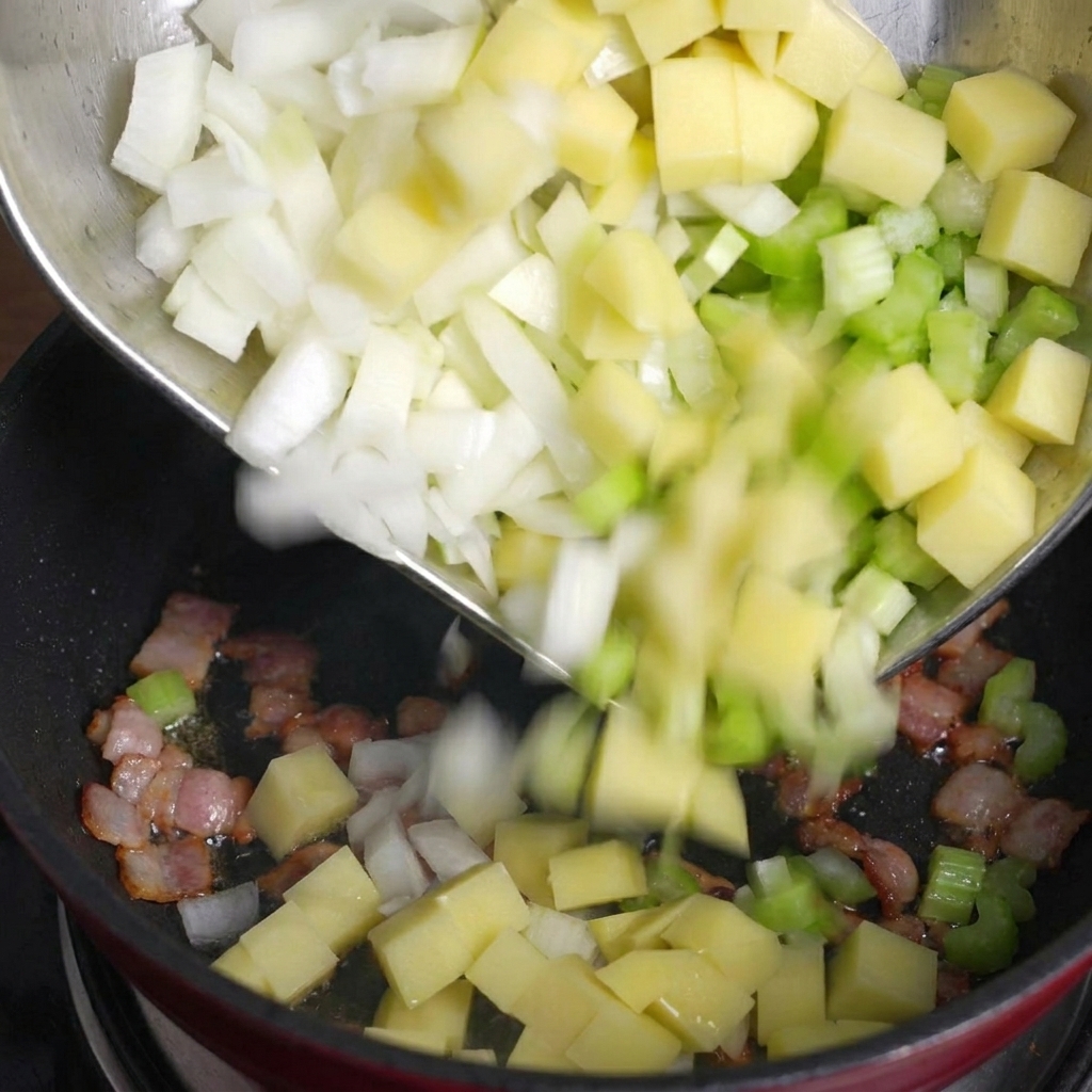 ベーコンの入った鍋に、カットした野菜を加えている様子