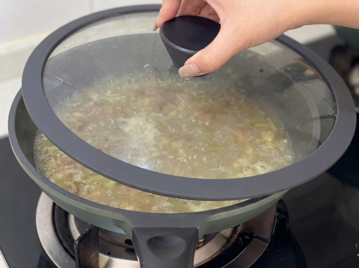 スープの入った鍋にガラスの蓋をして、じっくり煮込んでいる様子