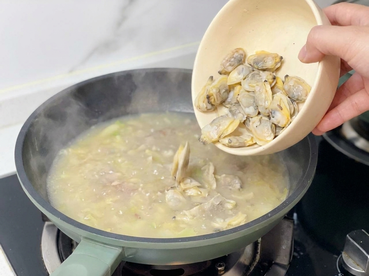 煮上がったスープにあさりの身を戻し入れている様子
