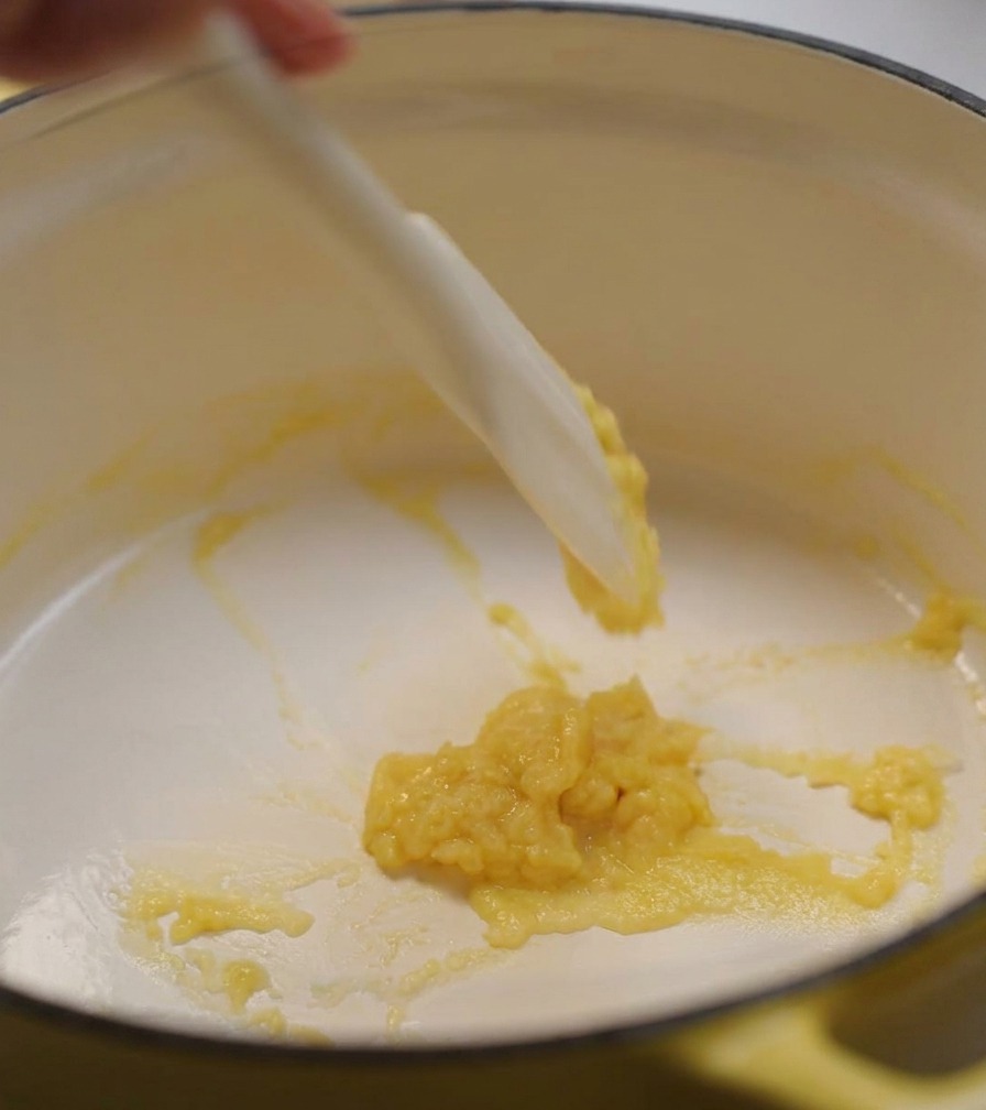鍋の中のルーに、牛乳と生クリームを混ぜながら少しずつ加えている様子