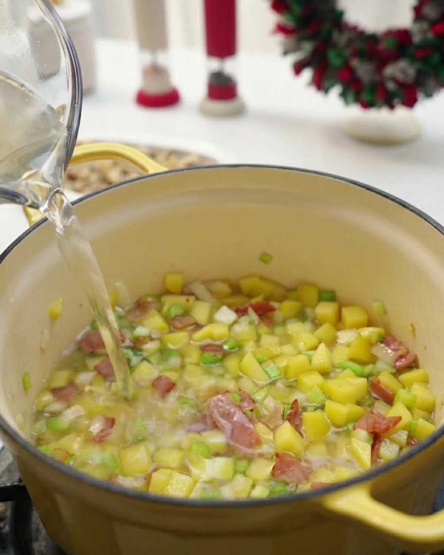 野菜が入った鍋に水を注ぎ、塩胡椒で味を整えている様子
