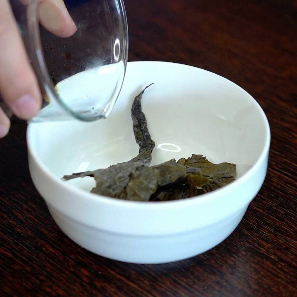 小さな白い器に入った乾燥昆布に濃口醤油を注いでいる様子。
