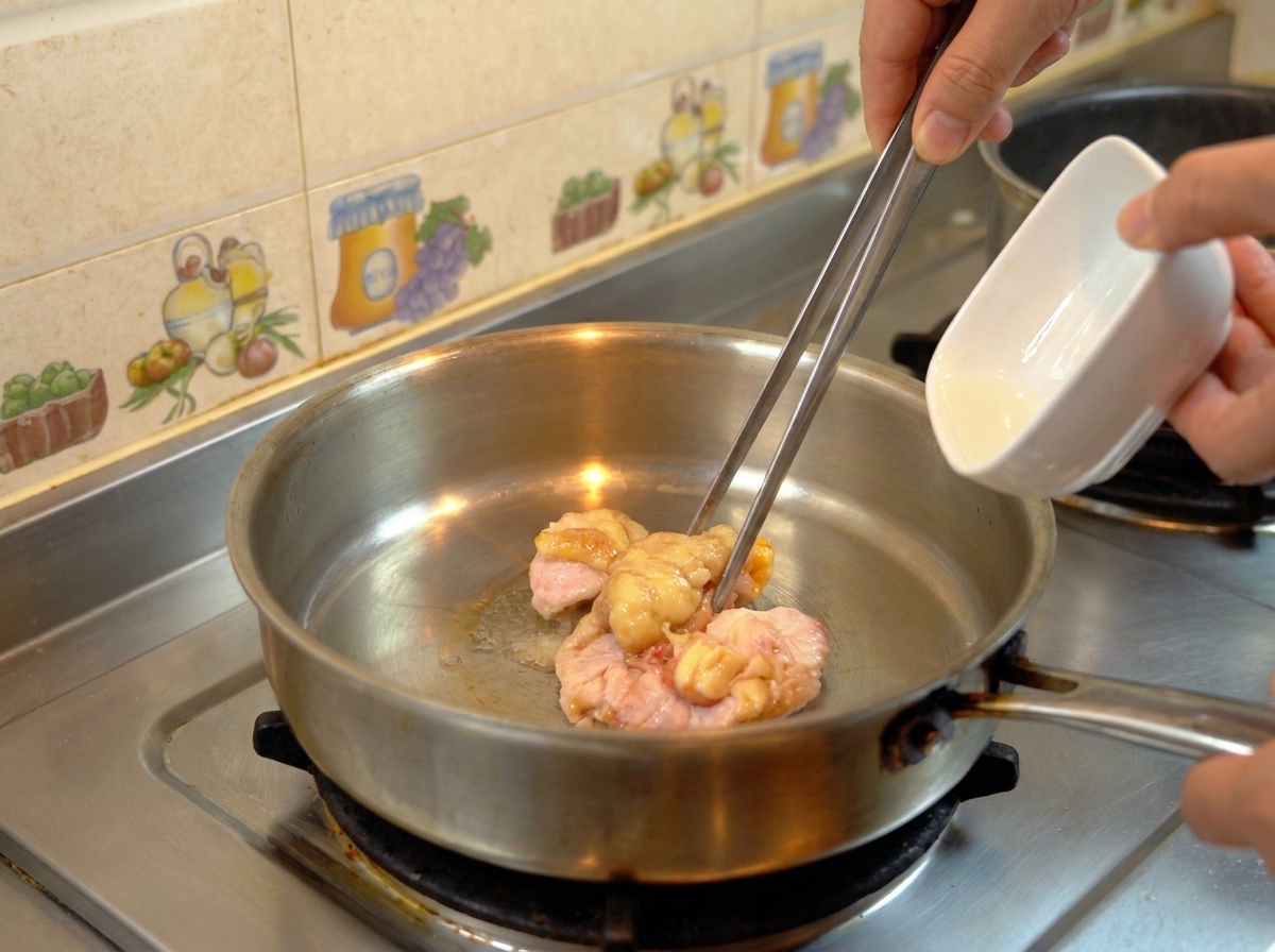 フライパンで生の鶏脂を加熱し、透明な油が出てきている様子。