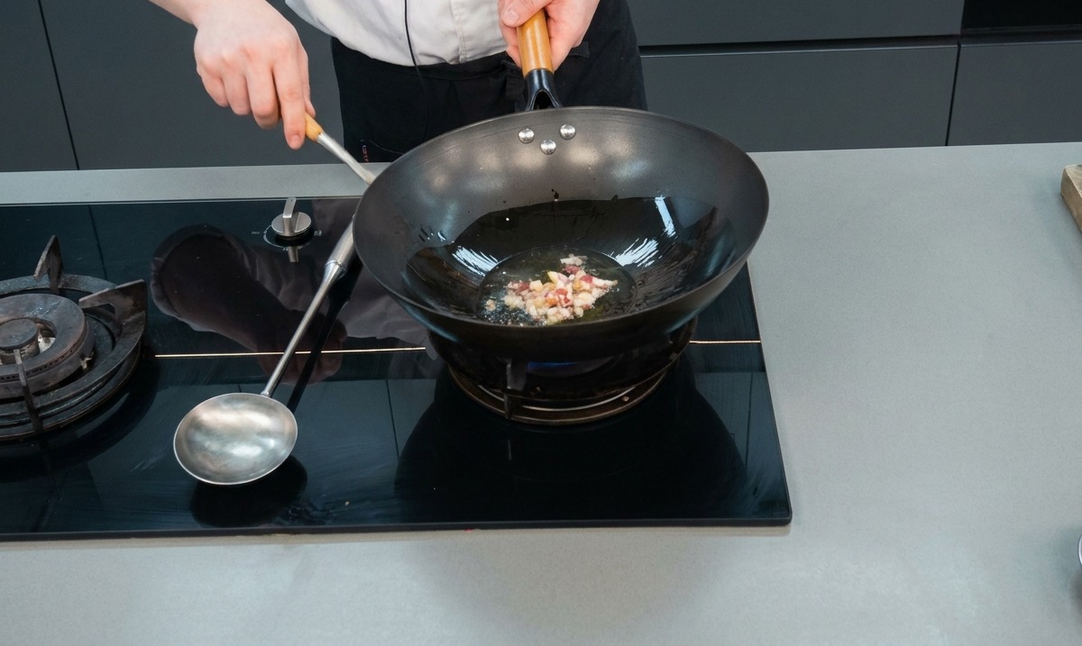 熱した中華鍋で、刻んだ肉とにんにくを炒めて香りを立たせている様子。