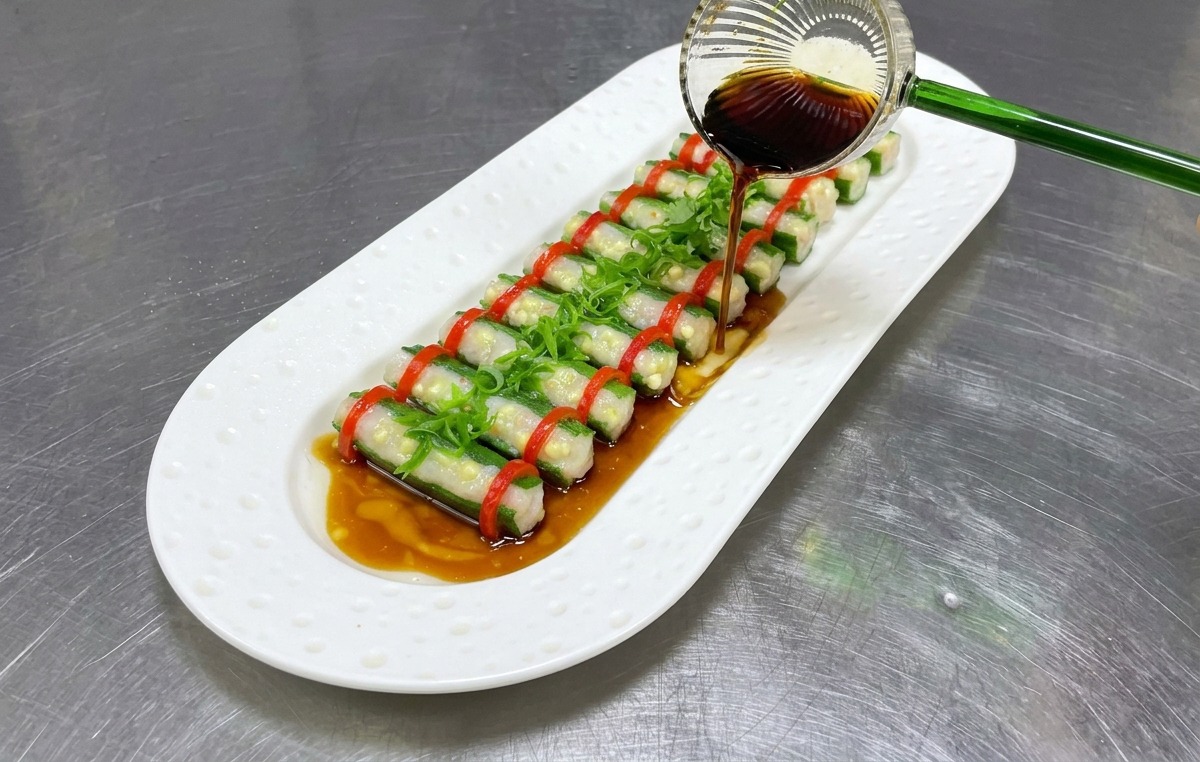 盛り付けられた料理全体に、特製醤油ダレをかけている様子。