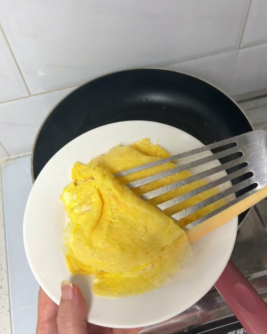 フライパンでベーコンがカリカリに焼け、脂が出ている様子。