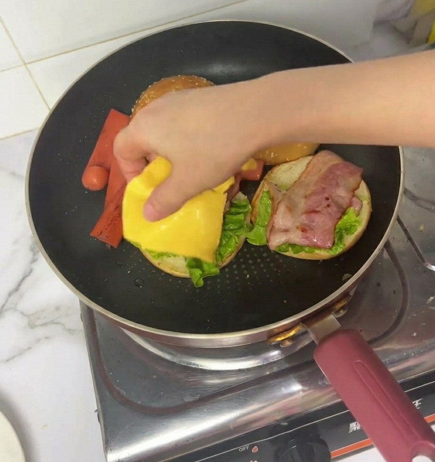 ベーコンの上にスライスチーズをのせる様子。