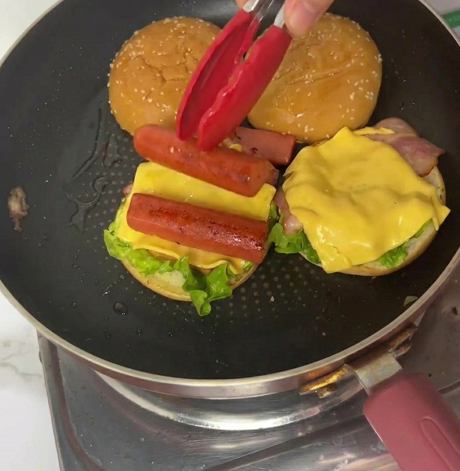 四角く切ったオムレツをバーガーの上にのせる様子。