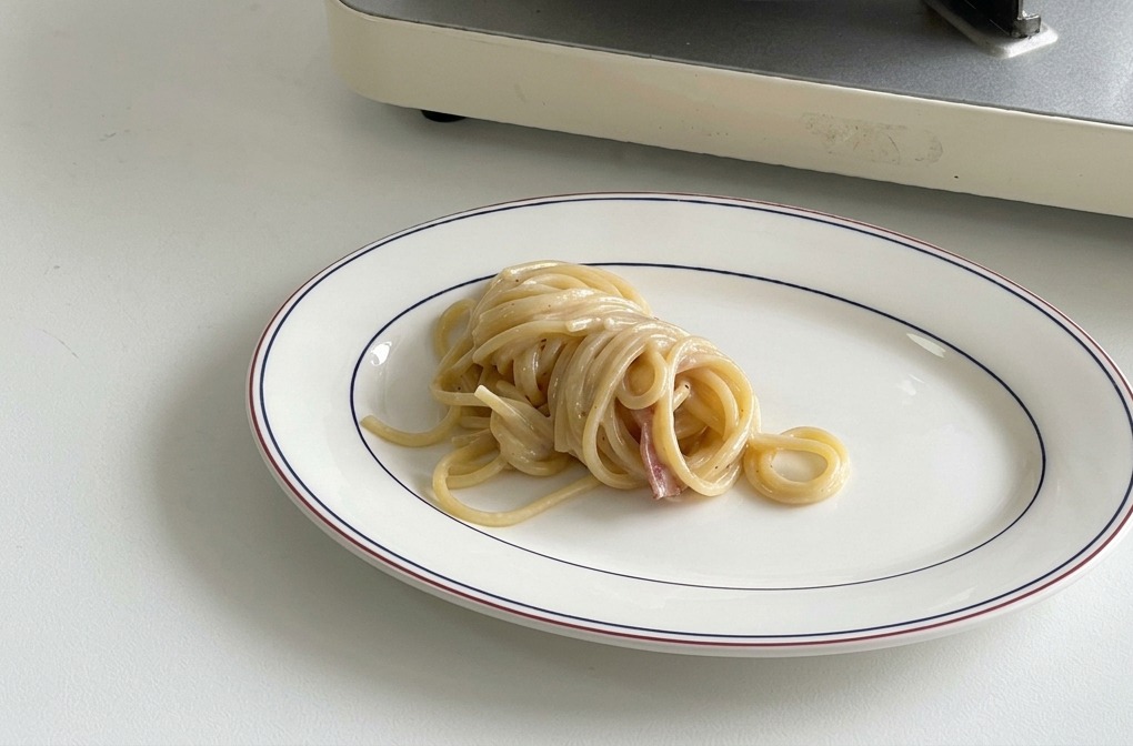 お皿の中央に、きれいに巻かれたスパゲッティが盛り付けられている様子。