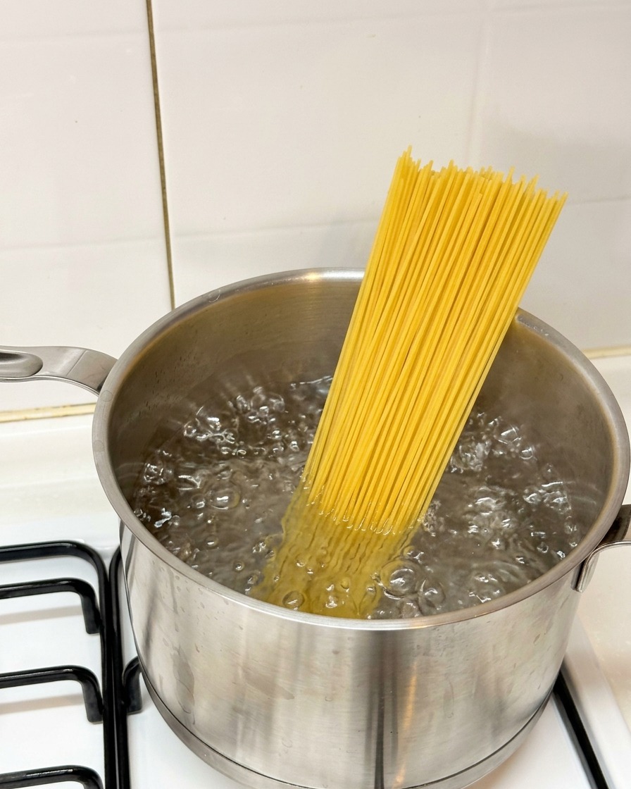 沸騰したお湯にスパゲッティを入れる様子。