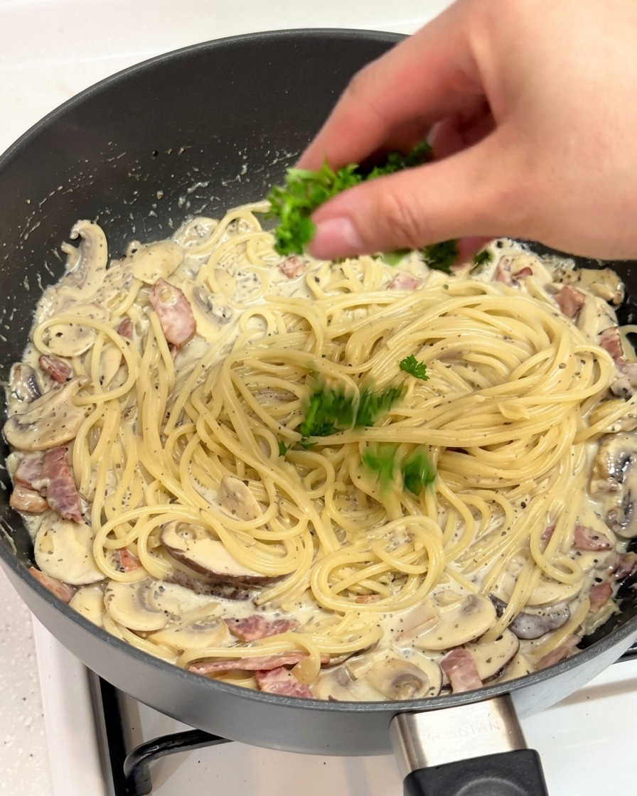 パスタの上に刻んだフレッシュパセリを振りかける様子。