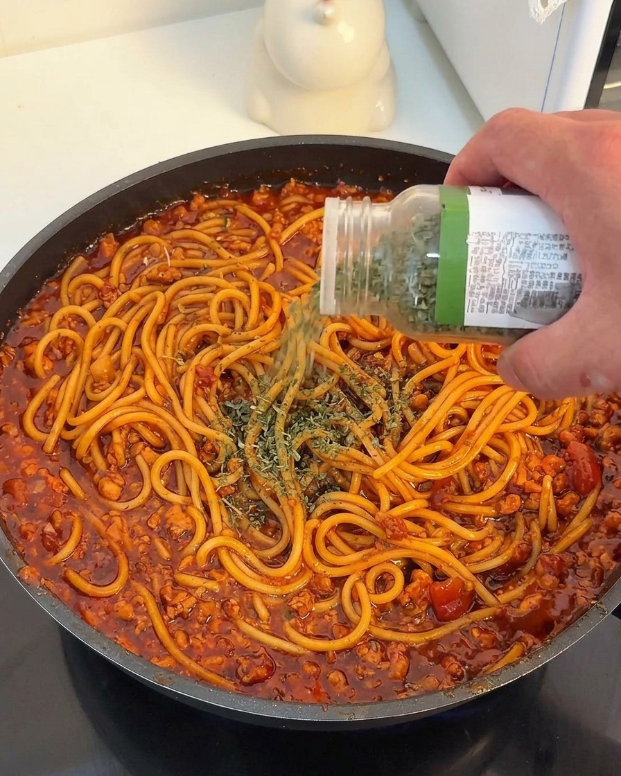 パスタに乾燥パセリを振りかけている様子。