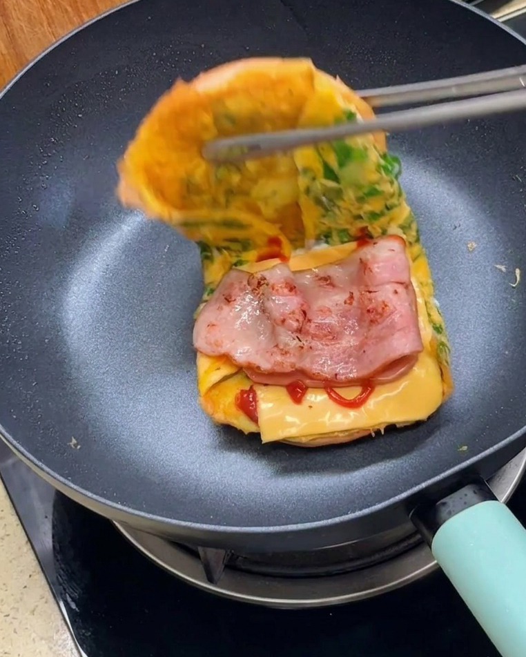 トングで2つのバンズを合わせ、バーガーを完成させている様子。