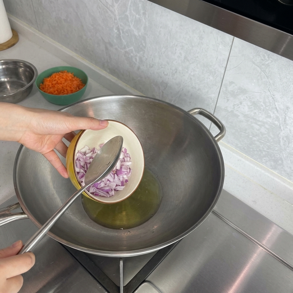 加熱したウォック(中華鍋)に赤玉ねぎを入れる様子。