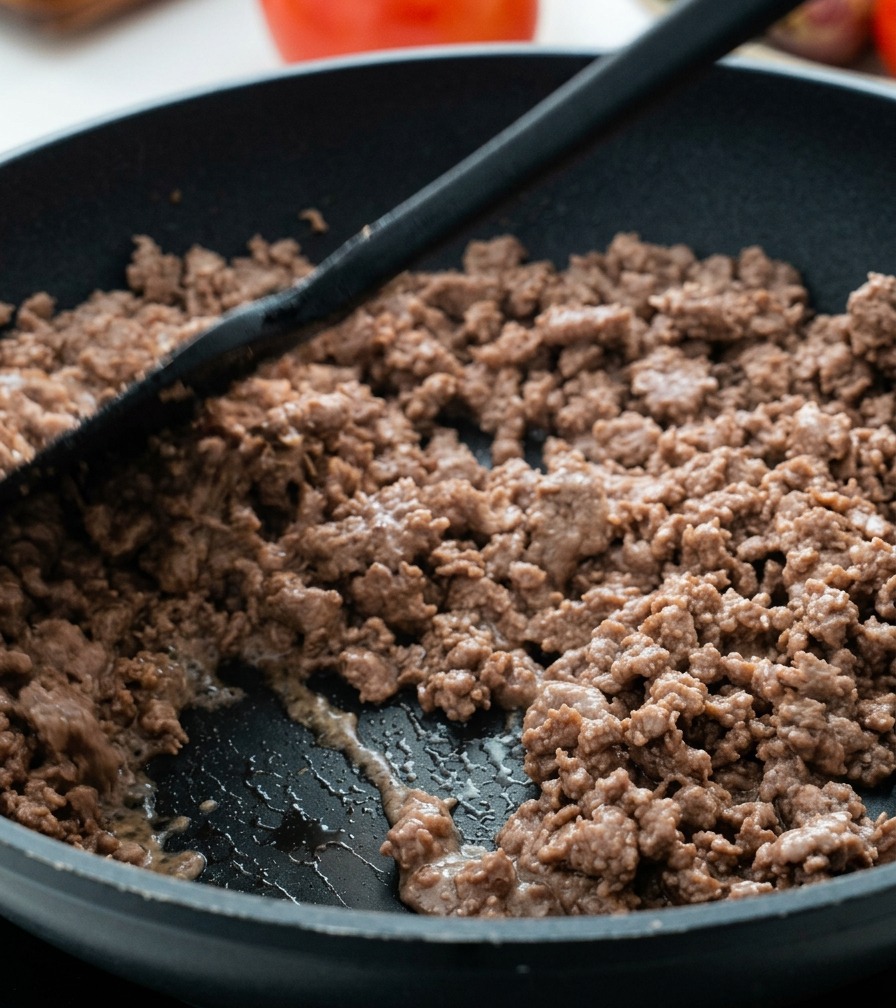 フライパンの中で焼き色がつき、脂が出てきた牛ひき肉を炒めている様子。
