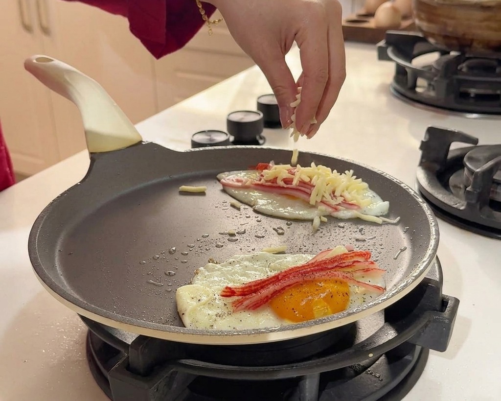 卵とカニカマの上にシュレッドチーズを均一に散らしている様子。