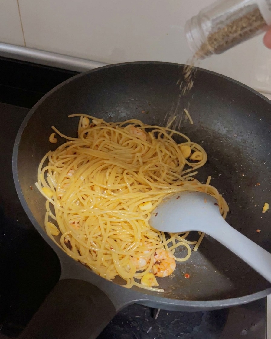パスタの上から黒胡椒を挽いている様子。