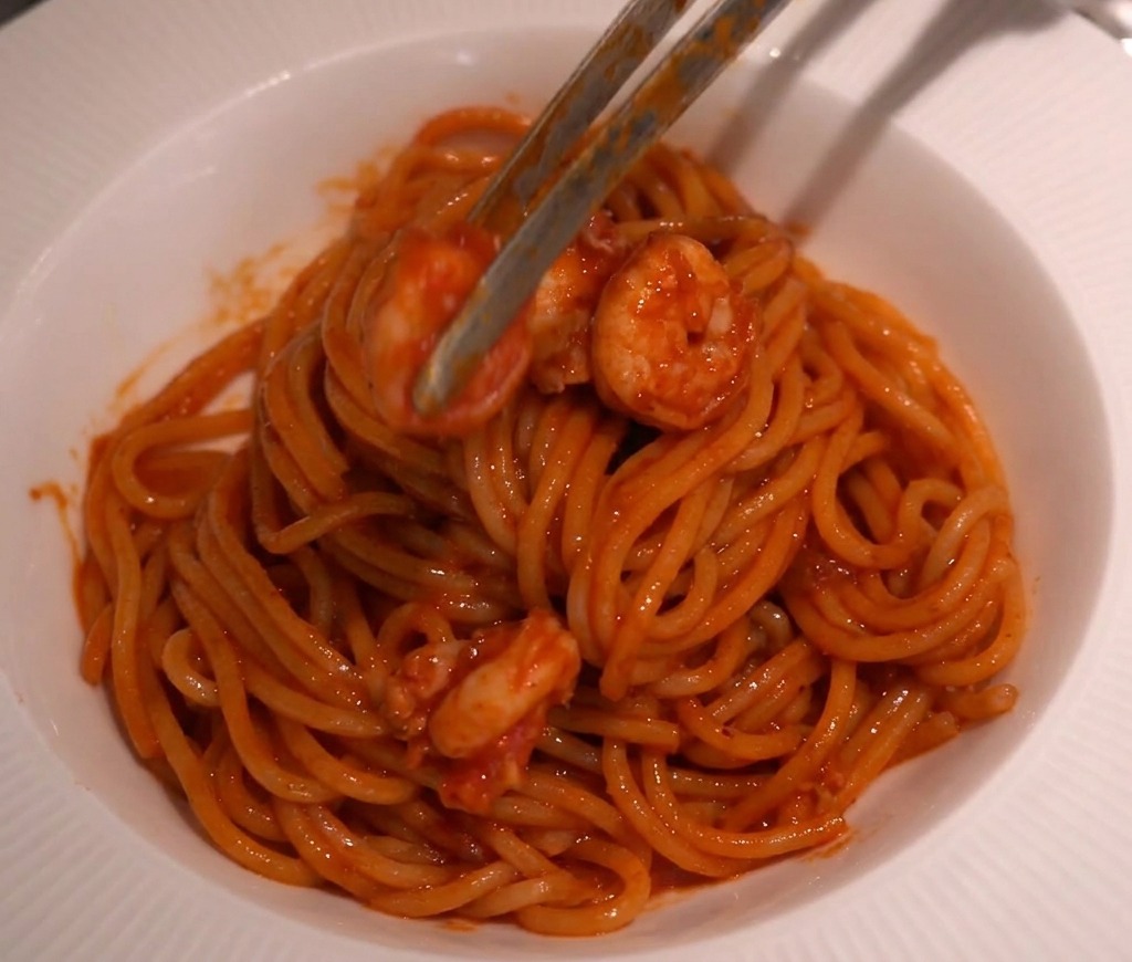 パスタの上にバランスよく海老をのせていく様子