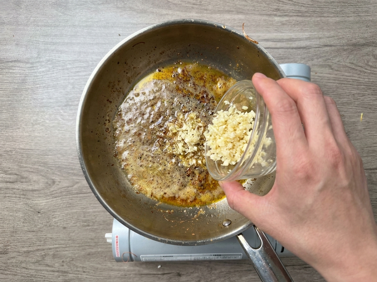 バターとオイルの中でにんにくのみじん切りを炒める様子。