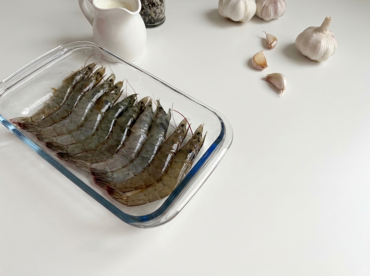 ガラス容器に並べられた生の新鮮なエビ。
