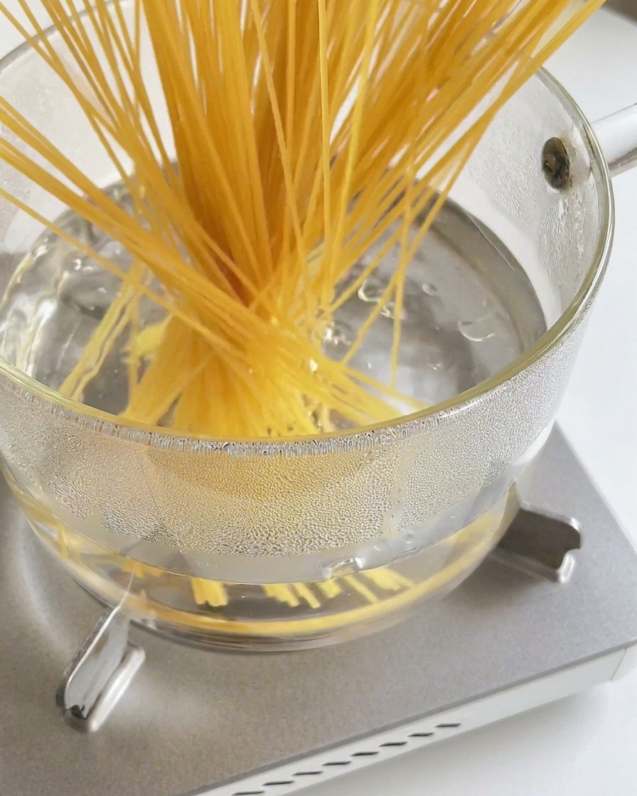 沸騰したお湯に乾燥スパゲッティを入れている様子