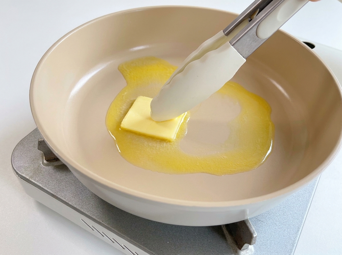 フライパンで四角いバターが溶けている様子