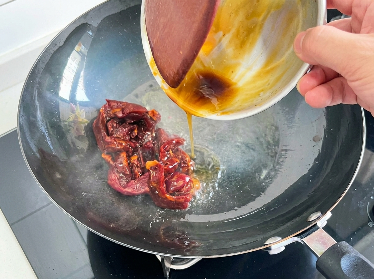 表面が色づいた牛肉を鍋で炒める様子。