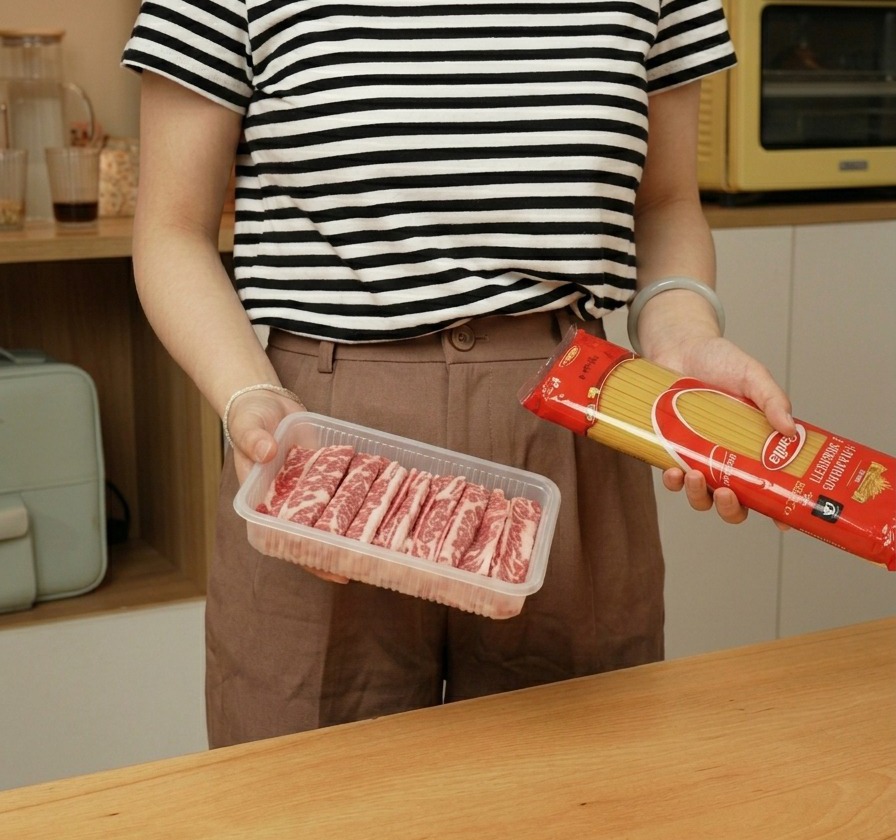 パッケージに入ったスパゲッティと、トレイに並んだ生の牛薄切り肉。