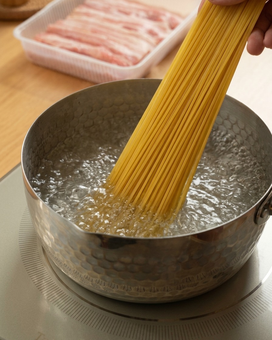 激しく沸騰した鍋にスパゲッティを広げて入れる手元。