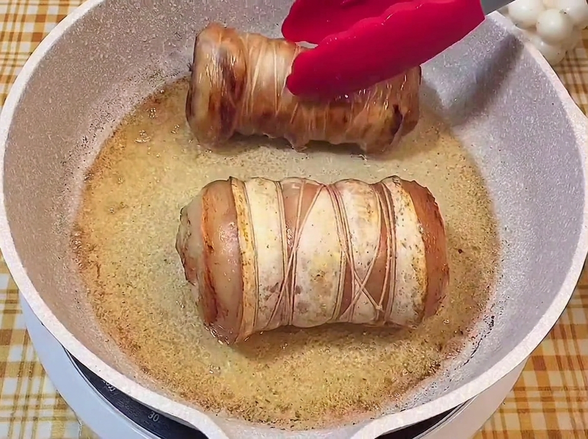 フライパンの中で全面が美味しそうなきつね色に焼けた2つのロールチャーシュー。