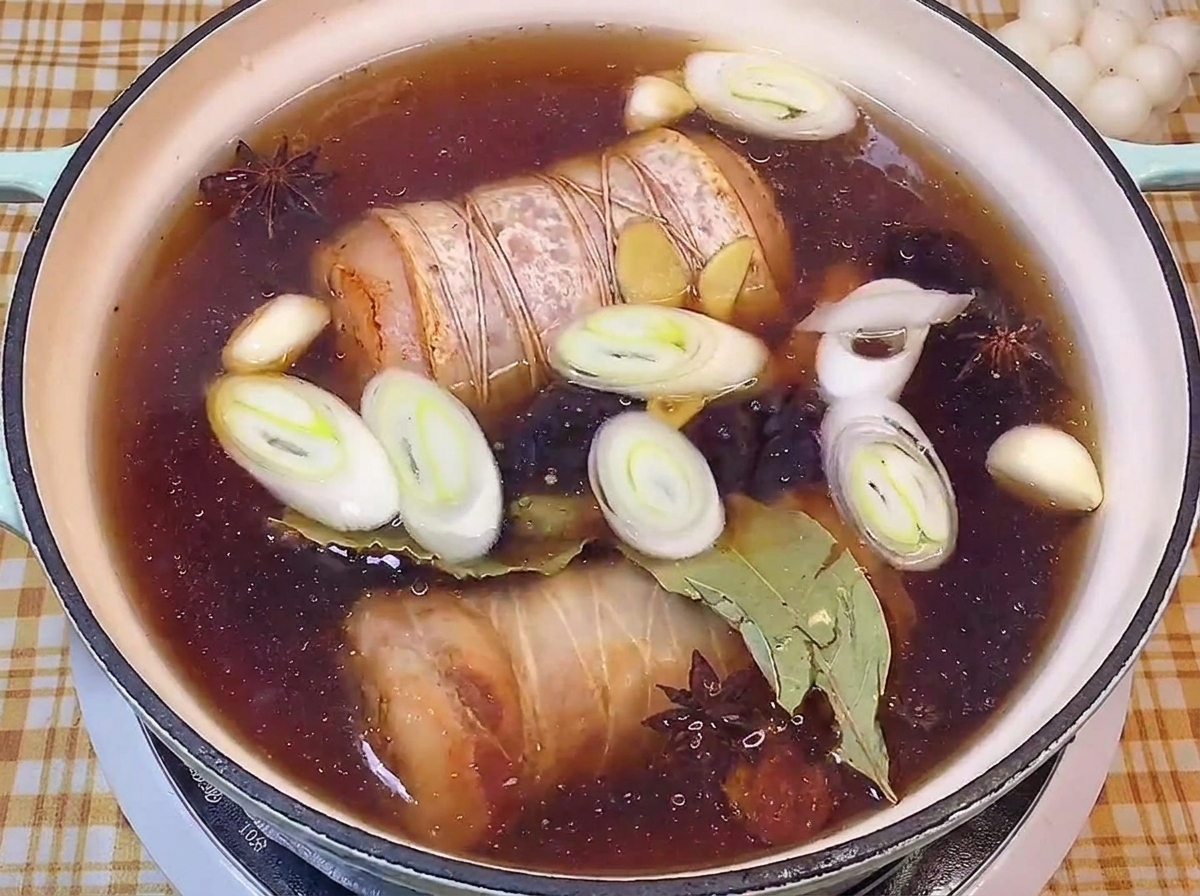 長ねぎやスパイスが入った濃い醤油ベースの煮汁の中でコトコト煮込まれる豚肉。