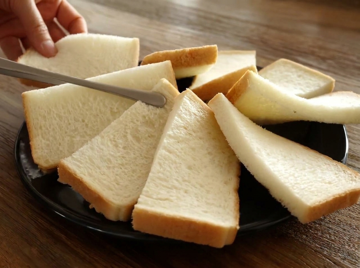 黒い耐熱皿の上に、半分に切った食パンを円形に少しずつ重ねて並べた様子。