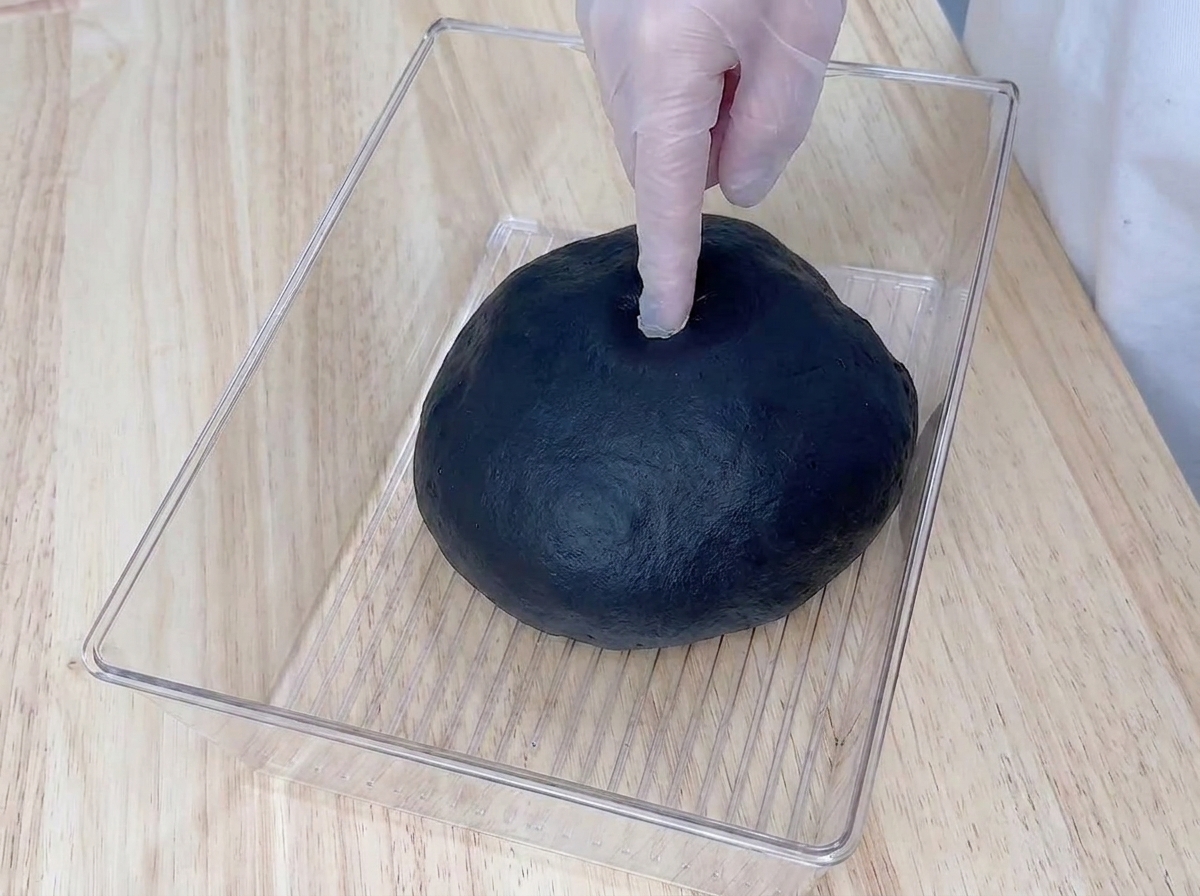 膨らんだ黒い生地の中央に、指で穴を開けて状態を確認している様子。