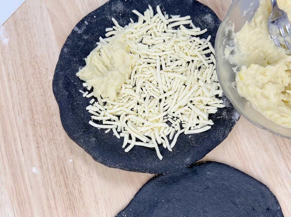 チーズの上に、ペースト状にしたドリアンをスプーンで塗り広げている様子。