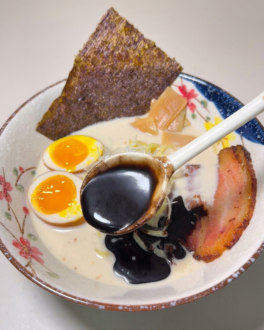 仕上げに真っ黒なマー油をスープの表面にひと回ししている様子。