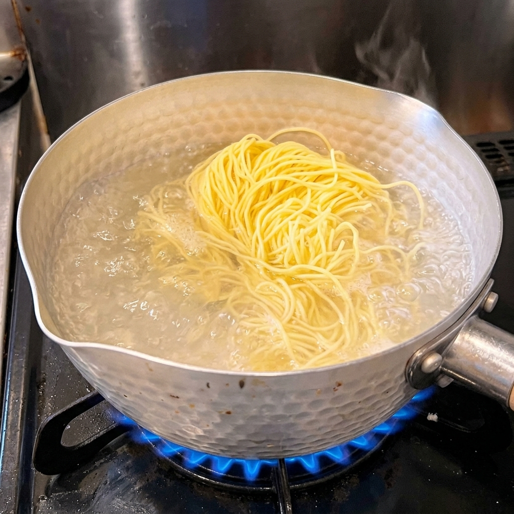 たっぷりのお湯が沸いた鍋に、中華生麺を入れている様子。