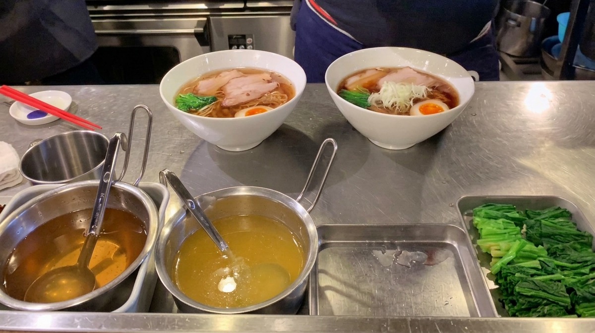 湯気の立つラーメンの中央に、細かく刻んだ白ねぎを盛り付ける様子