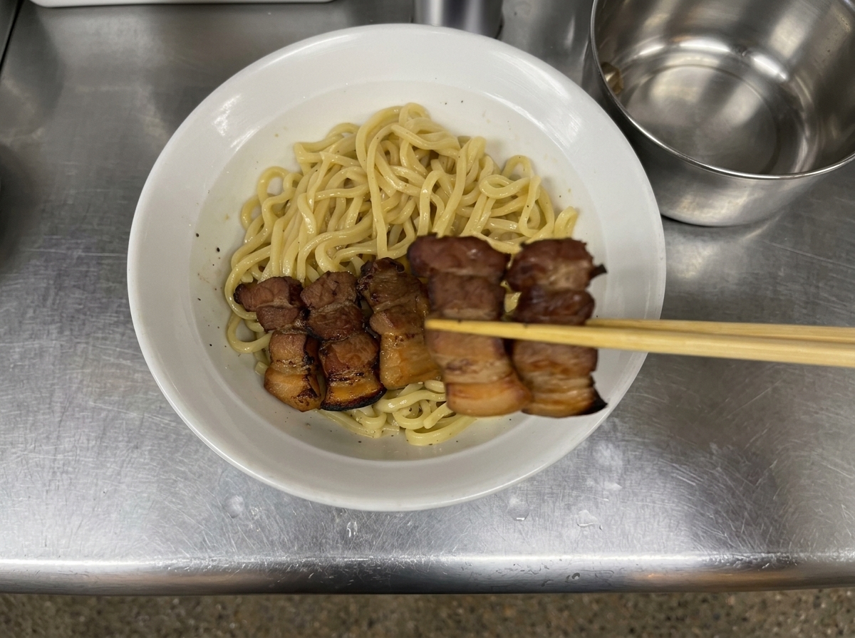 麺の上に厚切りのチャーシューをきれいに並べている様子。