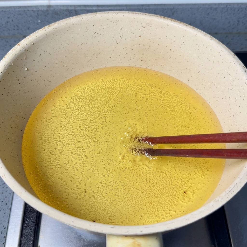 熱い油の中で泡立つ菜箸の先。